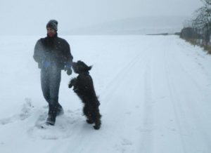 Homme joue avec son chien dans la neige Priyaka